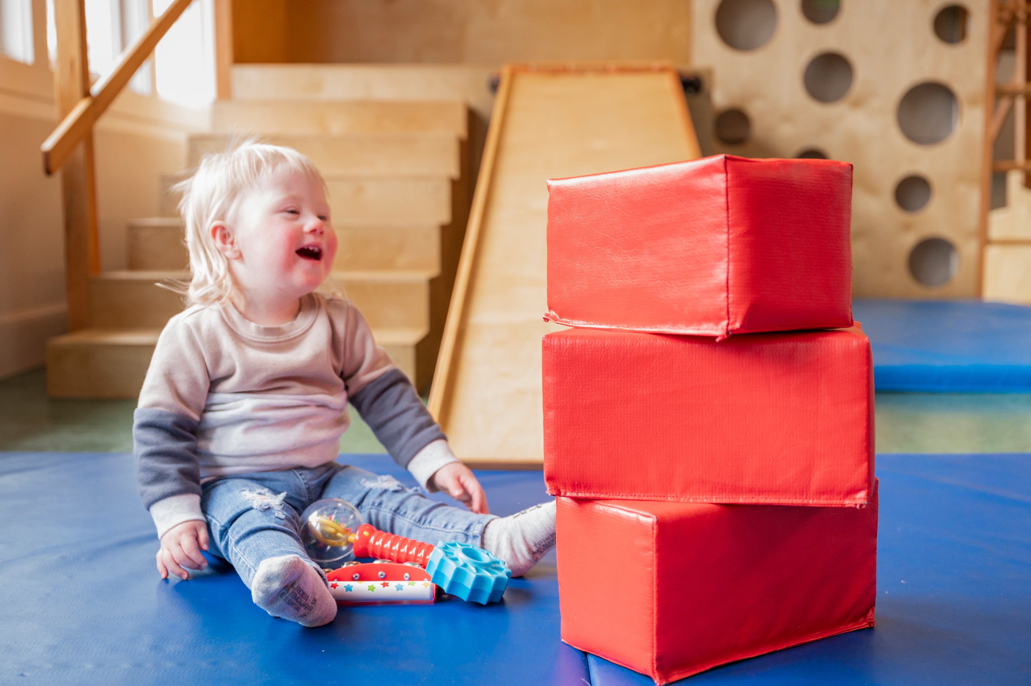 a little girl beside a pile of brick